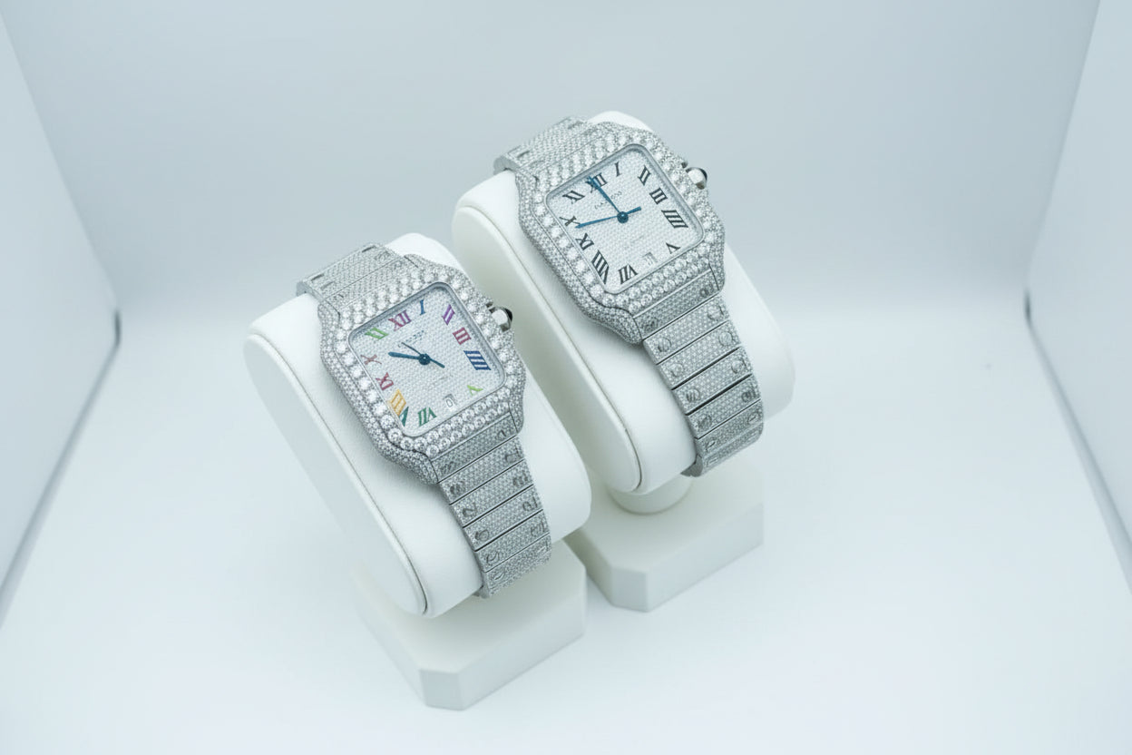 Two silver watches with diamond-studded faces on white stands.